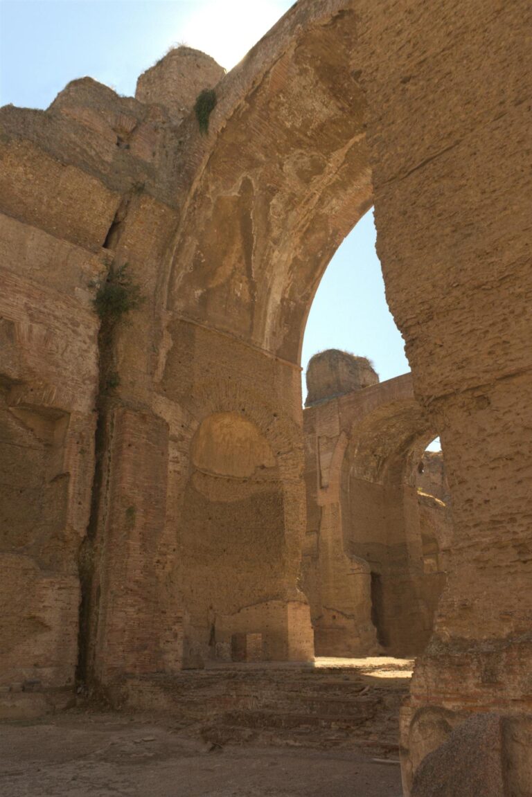 Explore the ancient arches of Rome's Baths of Caracalla under the bright sun.